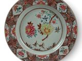 a plate with a floral design on it on a stand