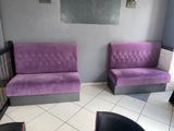 deux canapés violets dans un coin de la pièce