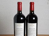 two bottles of wine sitting on a wooden table