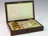a wooden box with silverware in it on a white surface