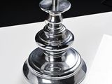 a silver candle that is sitting on a white table
