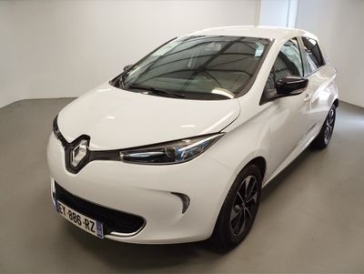 La voiture blanche est garée dans une grande pièce.
