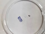 a white plate with blue writing on it sitting on a table