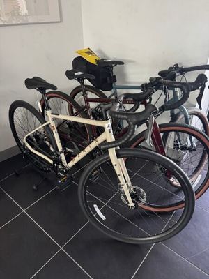 Plusieurs vélos sont alignés contre un mur dans une pièce