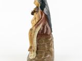 a statue of a woman sitting on top of a rock