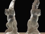 two figurines of horses that are sitting on a table