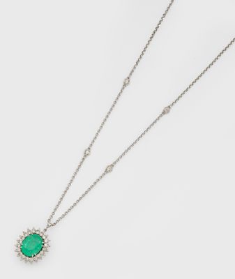 un gros plan d'un collier composé d'une pierre verte montée sur une chaîne