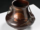 a brown vase sitting on top of a white table