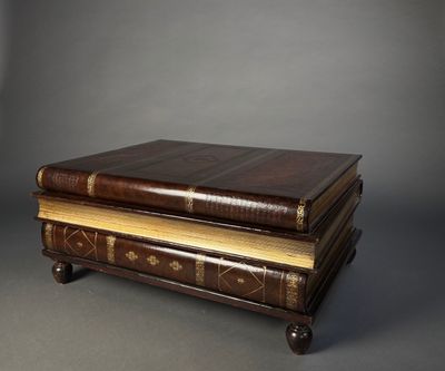 two old books stacked on top of each other on a table