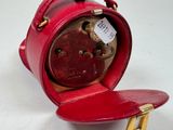 a small red clock sitting on top of a table