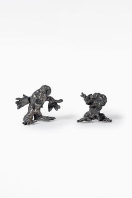 pair of bronze figurines of a boy and a girl on a white background