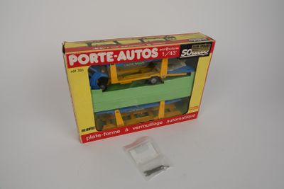 une boîte contenant un camion jouet, posée sur une surface blanche
