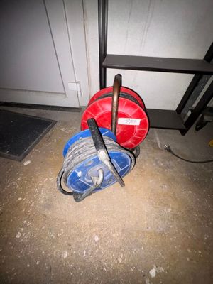 un tuyau rouge et bleu et un seau bleu posés par terre