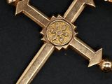 an image of a gold cross with a gold medallion on it