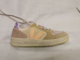 beige and purple sneakers with laces on a white surface