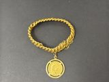un bracelet en chaîne d'or orné d'une breloque en forme de pièce de monnaie