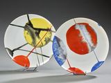 two plates with different designs on them sitting on a table