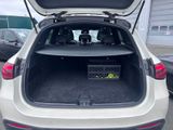 the back of a white car with its trunk open in a parking lot