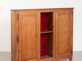 a wooden cabinet with a red door in a room