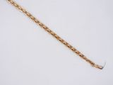 a close up of a gold chain on a white surface