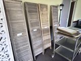many wooden shutters in a room next to a table
