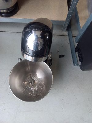 a bowl with a whisk inside of it on the floor