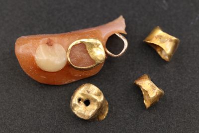 une image représentant une brosse à dents et quelques clochettes dorées sur un fond noir