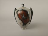 un vase blanc orné d'un motif rouge et noir