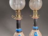 une paire de lampes à huile anciennes ornées de motifs bleus et blancs