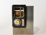 a metal object with a cigarette in it on a white surface