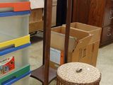 une pile de cartons posée à côté d'un tabouret dans une pièce