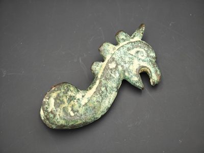 un gros plan d'un objet métallique orné d'une tête de cheval