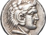 a silver coin with an image of a man wearing a headdress