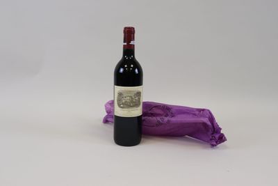 une bouteille de vin posée à côté d'un sac violet