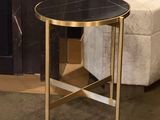 a black and gold side table with a white ottoman