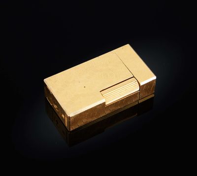un briquet doré posé sur une surface noire