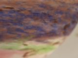 a close up of a bowl with a handle on a table