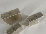 three clear boxes are sitting on top of a white table