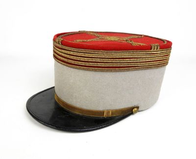 un chapeau blanc bordé de rouge, surmonté d'un chapeau noir