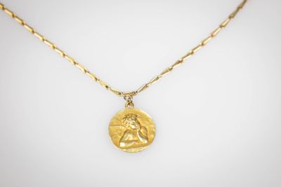 un collier plaqué or avec une pièce suspendue à une chaîne en or