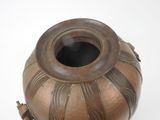 a brown vase that is sitting on a white surface