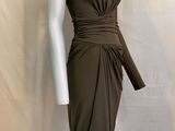Le mannequin porte une robe marron avec une ceinture.