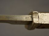 close up of a knife with a metal handle on a gray surface