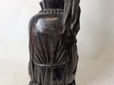 a statue of a person holding a vase on a table