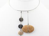 a close up of a necklace on a mannequin with stones