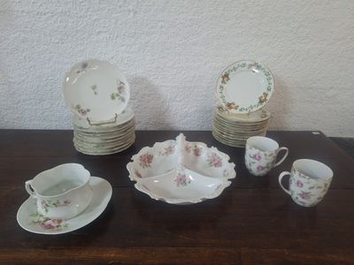 une table sur laquelle sont posés tout un tas d'assiettes, de tasses et de soucoupes