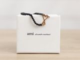 a white box with a black beaded bracelet on it