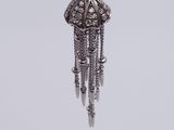 a close up of a silver necklace with a tassel hanging from it
