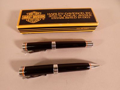 two pens sitting next to each other on a table