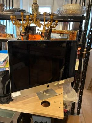 un écran d'ordinateur posé sur un bureau dans une pièce
